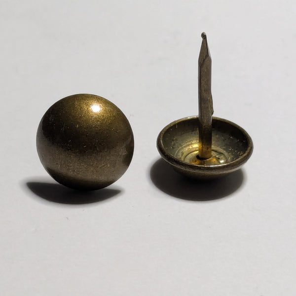 Two brass upholstery tacks on a white background